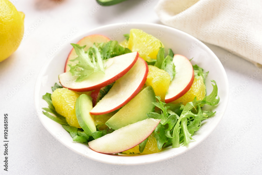 Fruit salad with red apples, avocado, orange slices