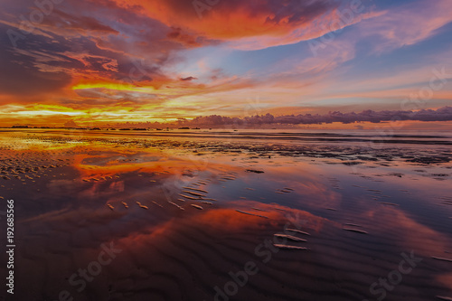 vibrant sunset and beautiful clouds with reflection. image contain soft focus due to long expose.