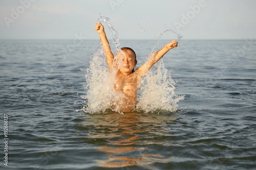 Fényképezés Spray with water. Girl having fun bathing in the sea.
