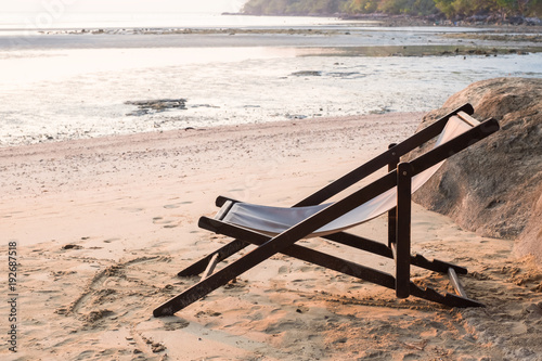 A chair on the sand beach in sunset