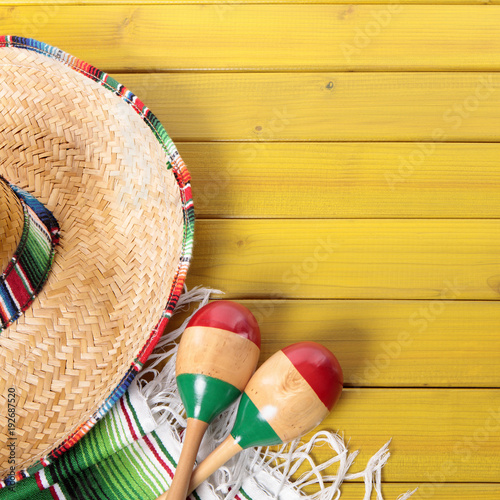 Cinco de mayo mexican background border with mexico sombrero straw hat blanket rug and maracas on old pine wood fiesta festival photo square format