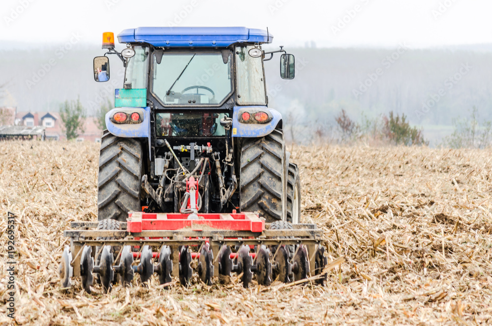 Fototapeta premium Modern tractor is working in the field