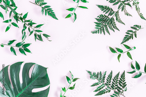 Leaf pattern. Green tropical leaves on pink background. Flat lay  top view  copy space