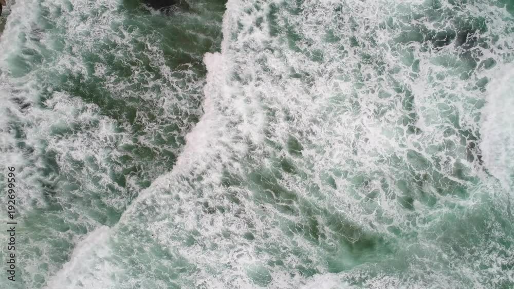 Aerial wild ocean waves crashing on a rocky coast ascending Aerial wild ocean waves crashing on a rocky coast ascending