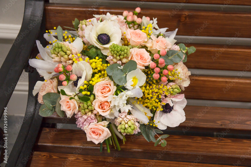 Beautiful designer white yellow pink wedding bouquet of florist with different flowers on wooden bench Beautiful designer white yellow pink wedding bouquet of florist with different flowers on wooden bench