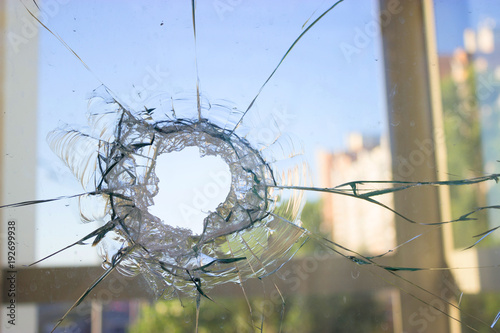 broken glass window reflecting blue sky photo