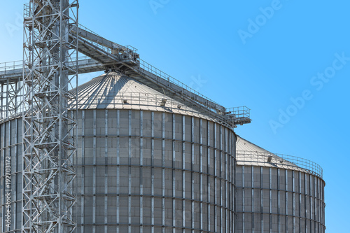 Agricultural Silos - Building Exterior, Storage and drying of grains, wheat, corn, soy, sunflower against the blue sky.