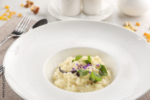rice porridge in a white plate on a white wooden background