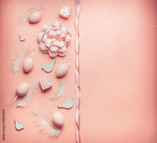 Pretty Easter pastel pink composing layout with eggs,ribbon,bow, birds and feather on table background, top view, flat lay