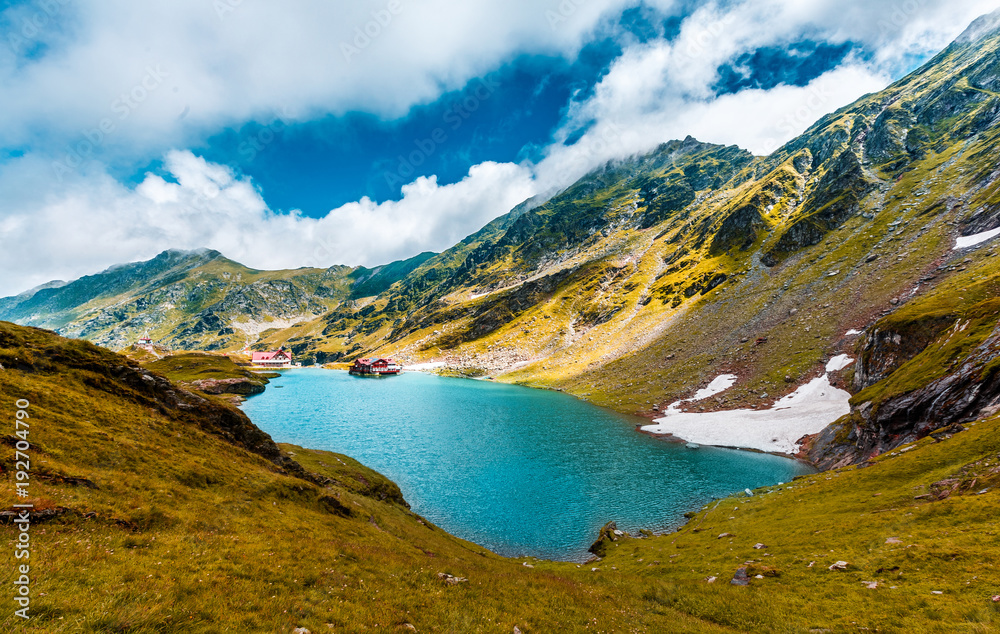Obraz premium wonderful sunny landscape. mountain lake with perfect sky. of Balea Lake glowing in sunlight. creative image. location. Balea lake. Transfagarasan highway, the most beautiful road in Europe, Romania