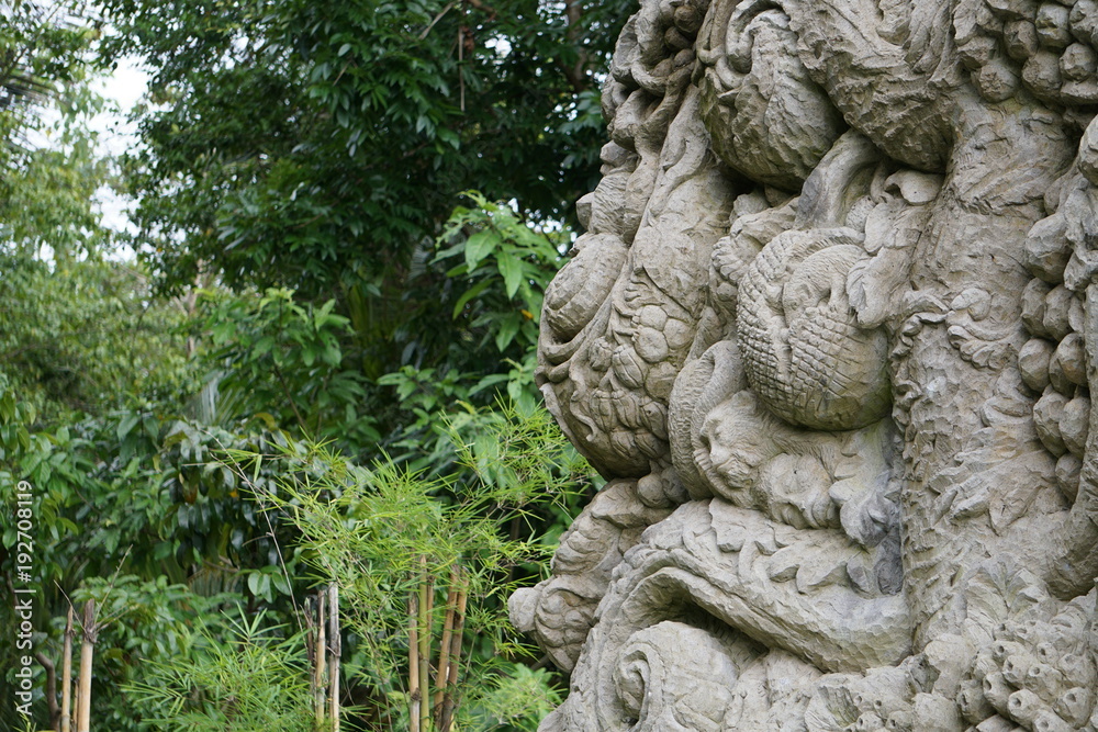 Wall and relief in Bali Indonesia with jungle in the back