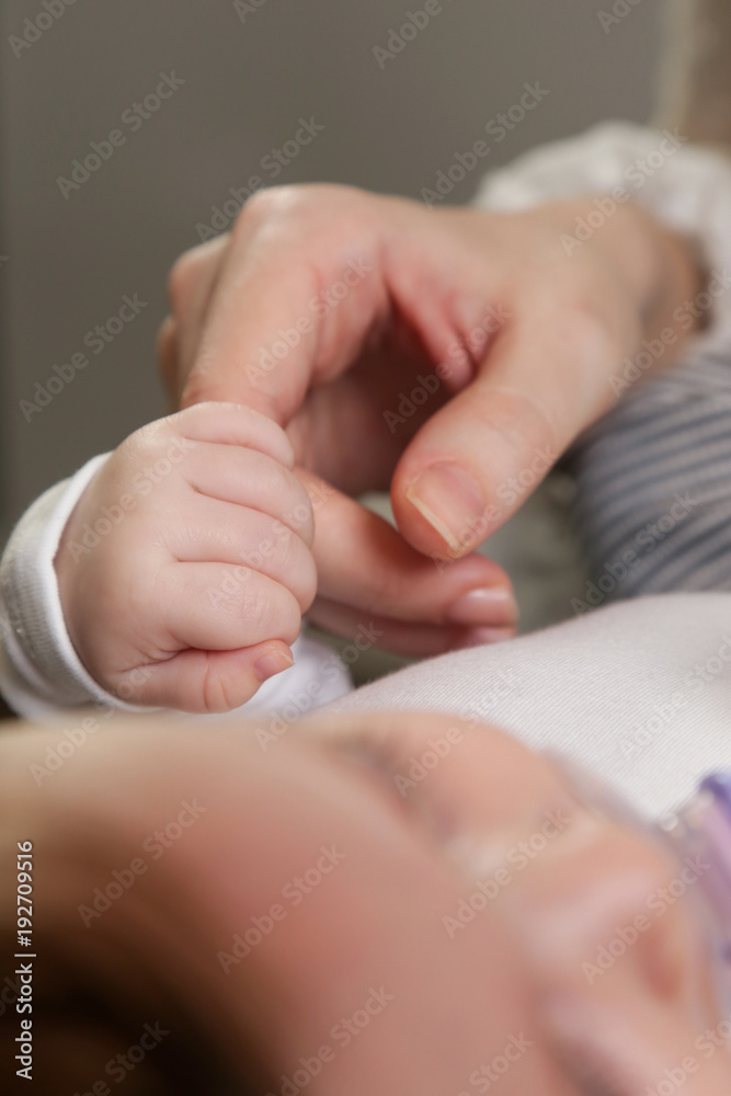 Newborn baby holding mother's finger Newborn baby holding mother's finger