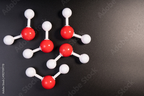 Chemistry model atom of molecule water scientific elements. Integrated particles hydrogen and oxygen atom on black background. Chemistry conceptual plastic model for education.