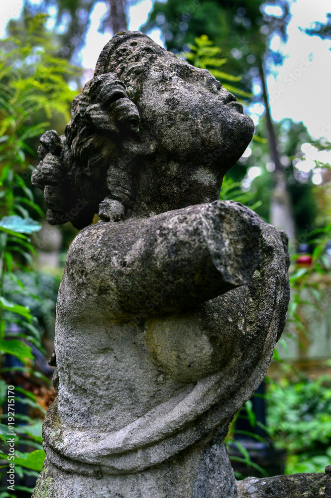 Side view of the wonderful ancient female statue with no hands installed on the abbadoned grave