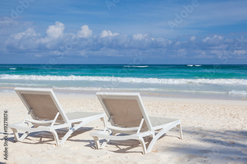Two white beach chairs on the empty beach   Yucatan  Mexico