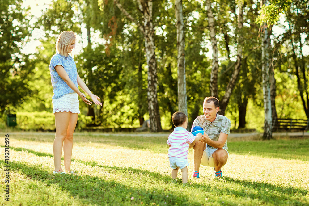 Happy family in nature. Parents with a child play in park. Happy family in nature. Parents with a child play in park.