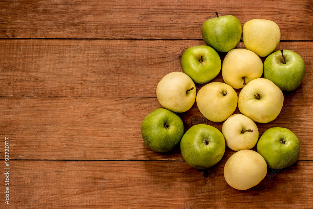 green and yellow apples on a brown wooden background green and yellow apples on a brown wooden background