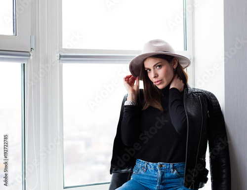 Beautiful boho woman in wool hat sitting by the window