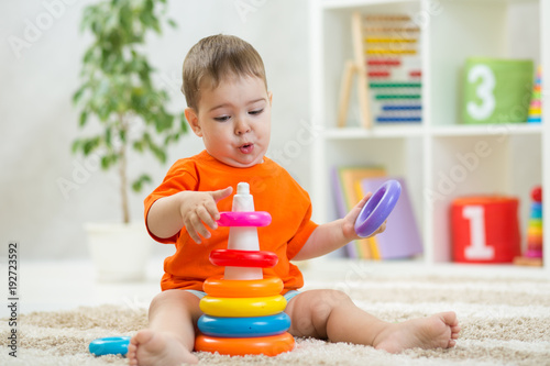 Baby plays sitting on floor...