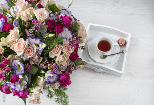 on the table a beautiful bouquet of flowers and a cup of tea, a cake