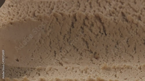 Slow motion closeup hazelnut praline ice cream scooping photo