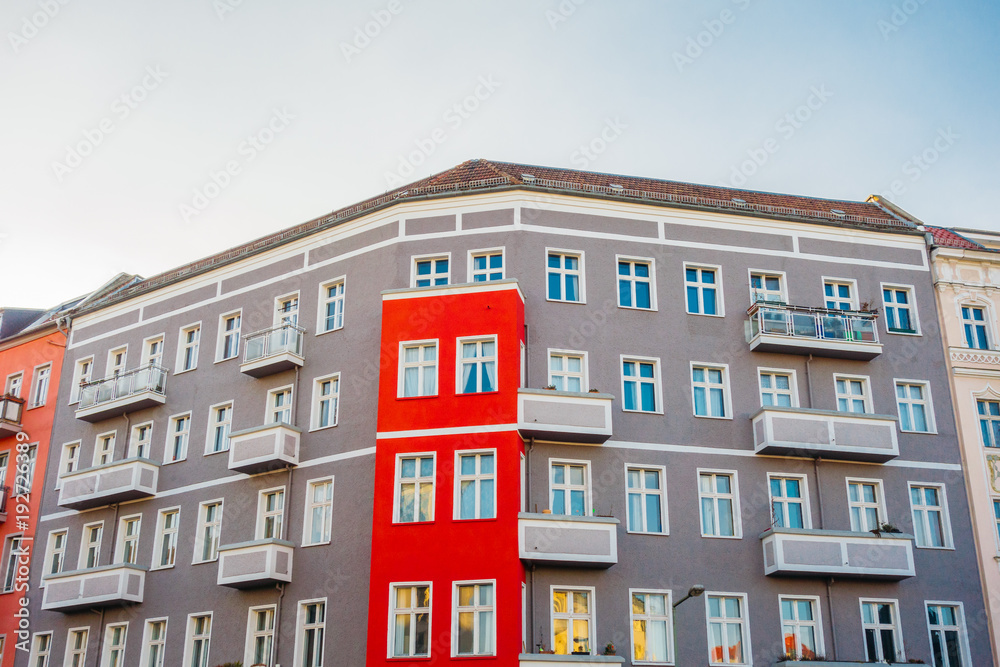 grey apartment house with red details in the middle