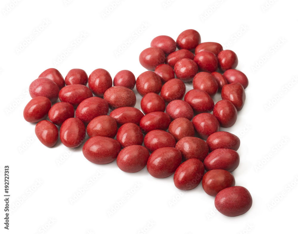 Candy covered with red icing and lined in a heart shape on a white background. Valentine's Day Candy covered with red icing and lined in a heart shape on a white background. Valentine's Day