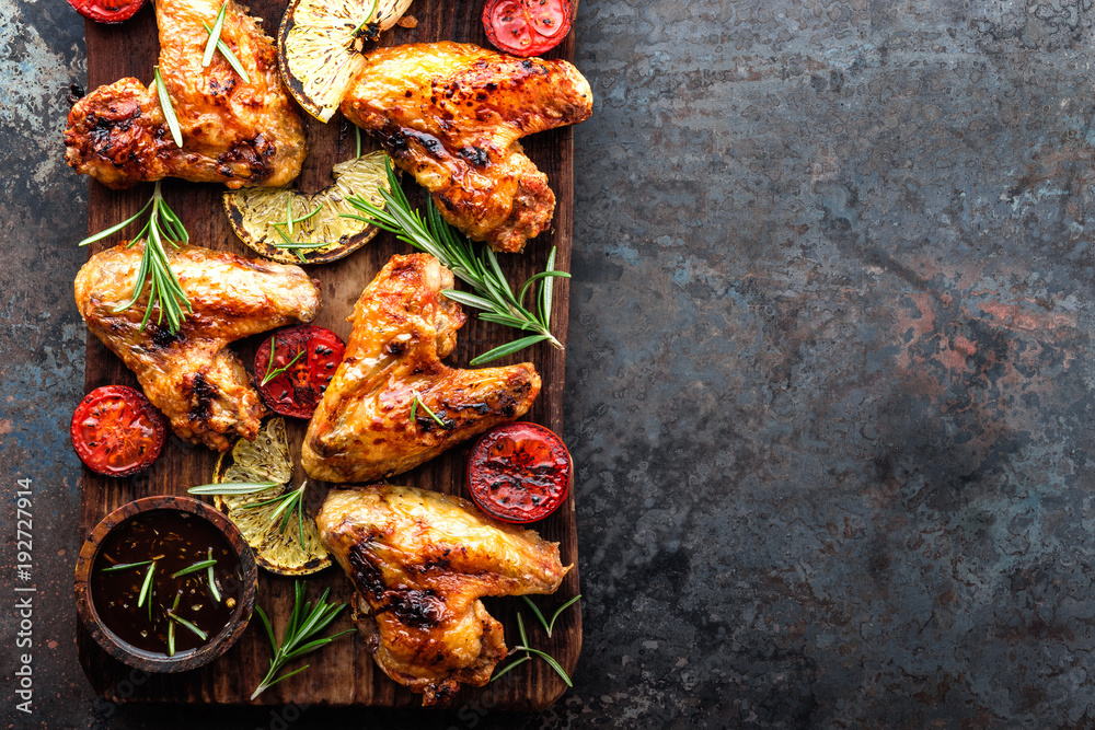 appetizing chicken wings grilled barbecue with spices and vegetables until crispappetizing chicken wings grilled barbecue with spices and vegetables until crisp, top view, space for text - obrazy, fototapety, plakaty 