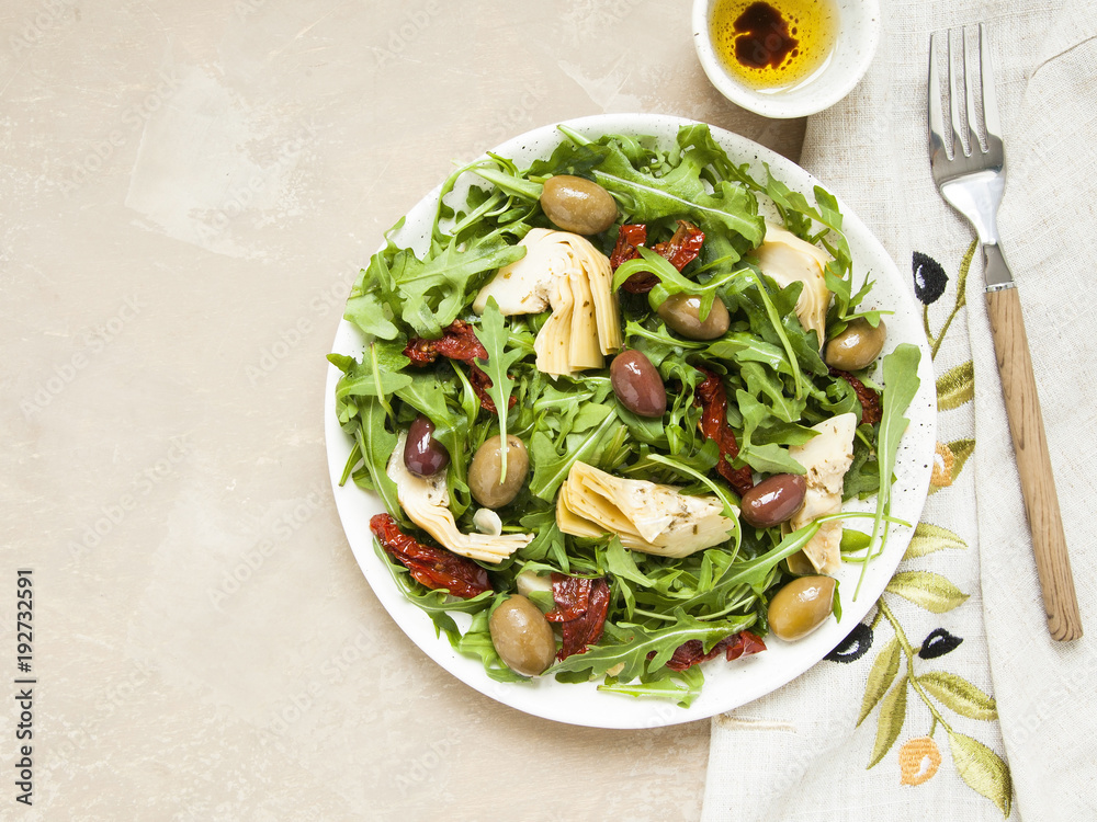 Tasty vegetarian salad with artichoke, rocket, sun-dried tomatoes and olives. 