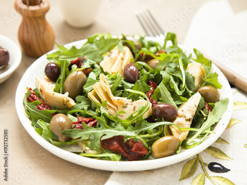 Tasty vegetarian salad with artichoke, rocket, sun-dried tomatoes and olives. 
