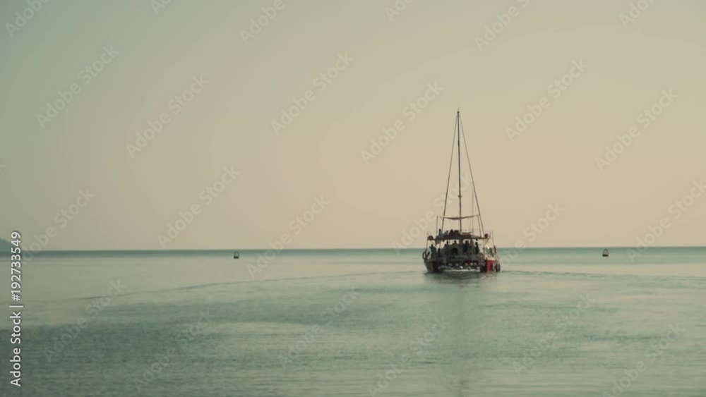 A Catamaran Sailboat in light blue water A Catamaran Sailboat in light blue water