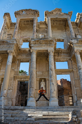 a tourist man is taking Ephesus Celsus Library's photo in a rainy day