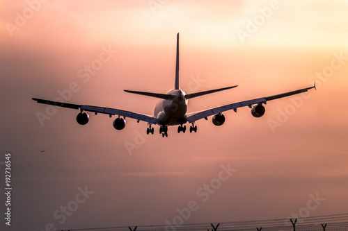Airplane landing at sunset © robertdering