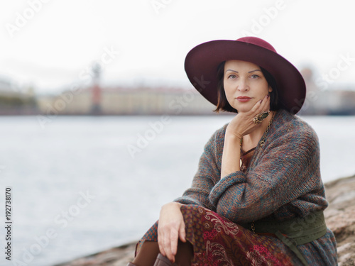 Женщина в бордовой шляпе в городе