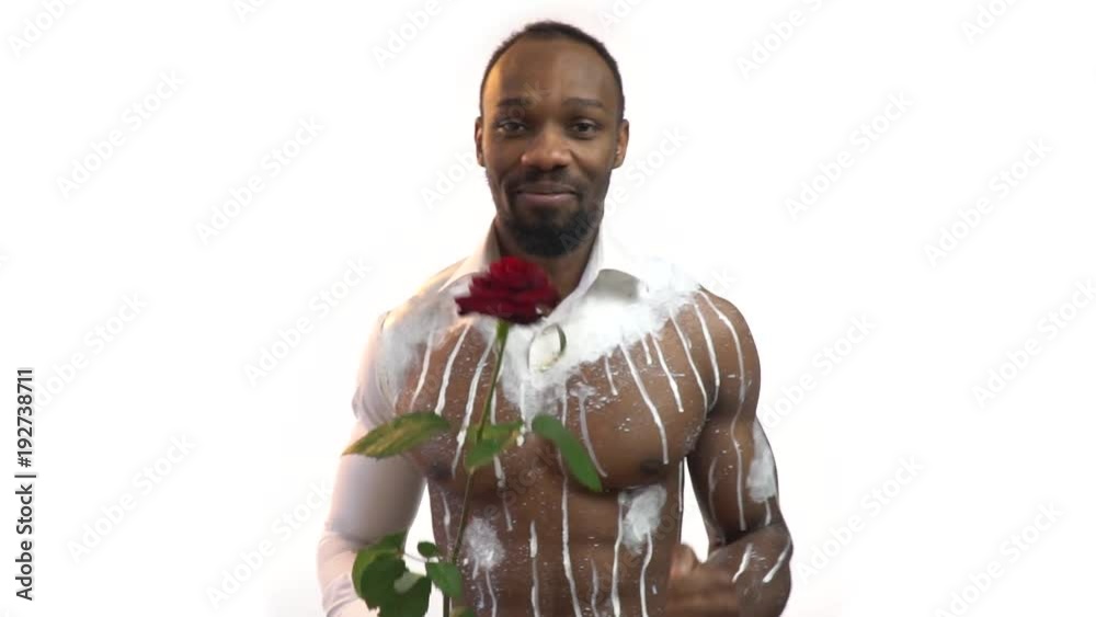 Muscular black man smiling and dancing with a red rose, slow motion Muscular black man smiling and dancing with a red rose, slow motion