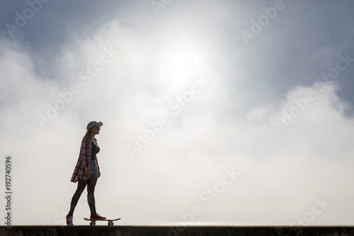 Silhouette of a cute girl riding a skateboard