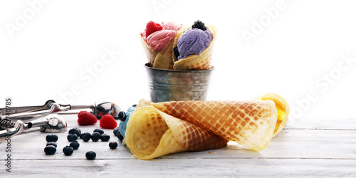 Set of ice cream scoops of different colors and flavours with blueberries, raspberries and blackberries.