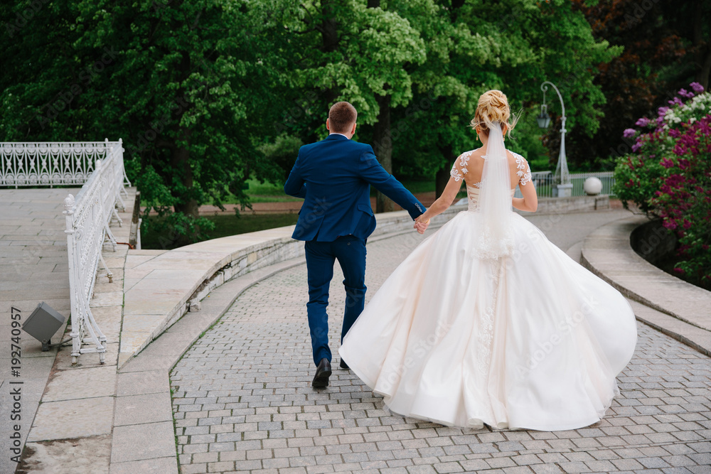 the bride and groom walk in the Park