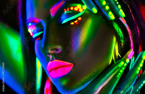 Fashion model woman in neon light. Portrait of beautiful model girl with colorful fluorescent makeup