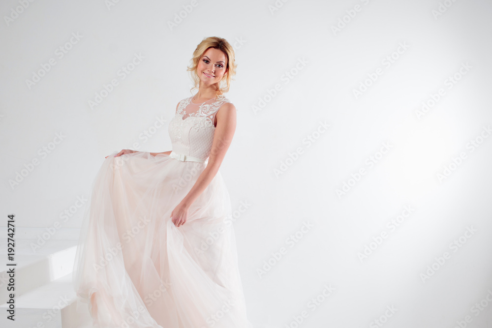 Portrait of a beautiful girl in a wedding dress. Bride, white background, free space on the right