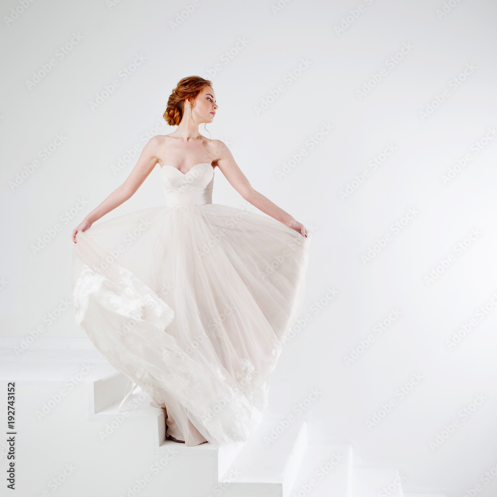 Portrait of a beautiful girl in a wedding dress. Bride in luxurious dress on a white background Portrait of a beautiful girl in a wedding dress. Bride in luxurious dress on a white background