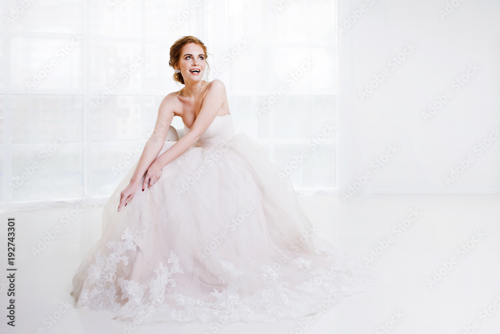 Portrait of a beautiful girl in a wedding dress. Bride in luxurious dress sitting on a chair Portrait of a beautiful girl in a wedding dress. Bride in luxurious dress sitting on a chair