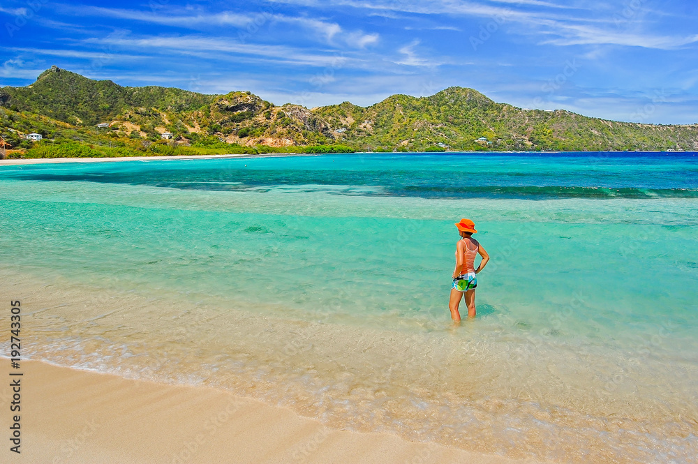 Young woman standing in shallow water on tropical beach, Union island, Caribbean Sea Young woman standing in shallow water on tropical beach, Union island, Caribbean Sea