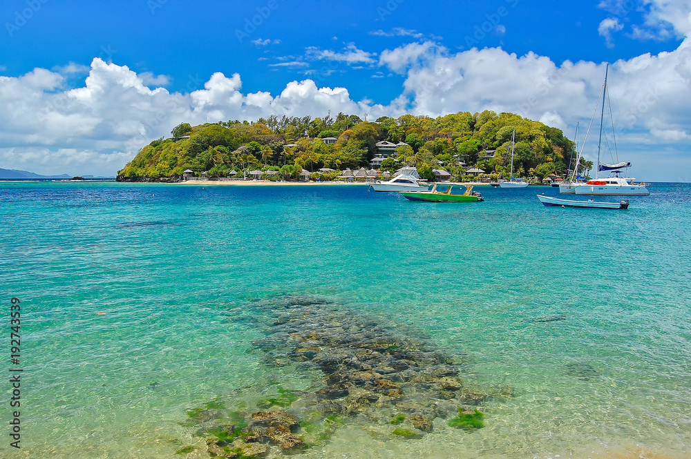 Boats anchoring near little island off coast of Saint Vincent island, Caribbean Sea region of Lesser Antilles