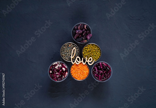 Concept of vegetarian food. Cereals and legumes with the inscription of love on a blue concrete background. Top view, empty space for text
