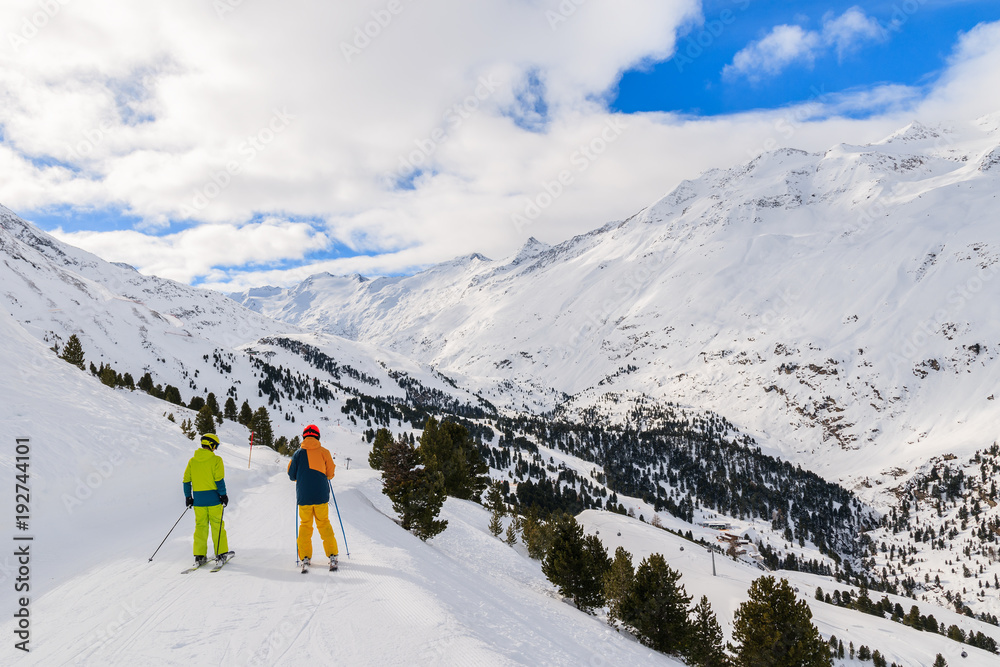 Two skiers on beautiful slope and mountain valley in winter season in Hochgurgl-Obergurgl ski area, Tirol, Austria