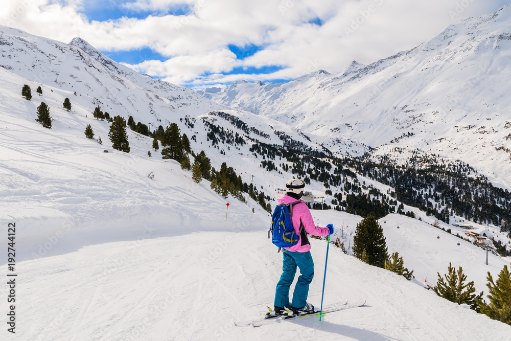 Young woman skier on slope and looking at beautiful mountain panorama in winter season, Obergurgl-Hochgurgl ski area, Austria