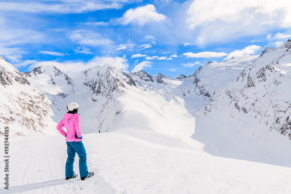 Young woman skier looking at beautiful mountains in winter season, Obergurgl-Hochgurgl ski area, Austria