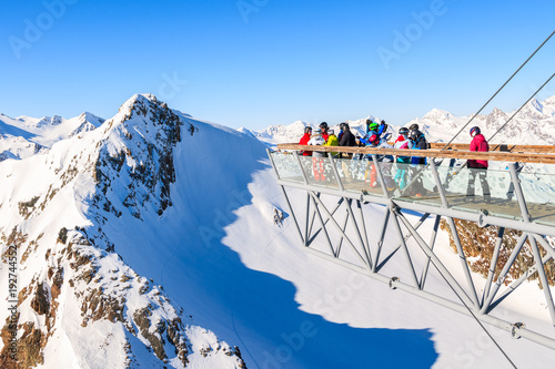 SOLDEN SKI RESORT, AUSTRIA - JAN 29, 2018: Skiers looking at mountains from platform in Solden ski area on beautiful sunny winter day, Tirol, Austria. photo