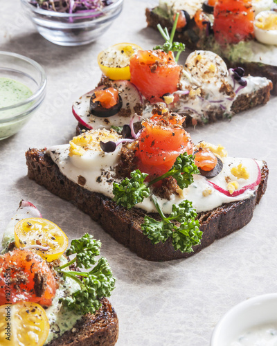 Danish open sandwich smorrebrod with herring, onion and eggs. Selective focus. Vertical.